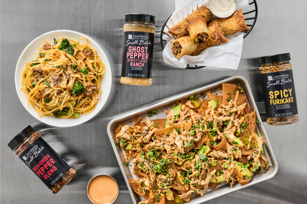 Dishes of food with Ghost Pepper Blend containers on a gray surface
