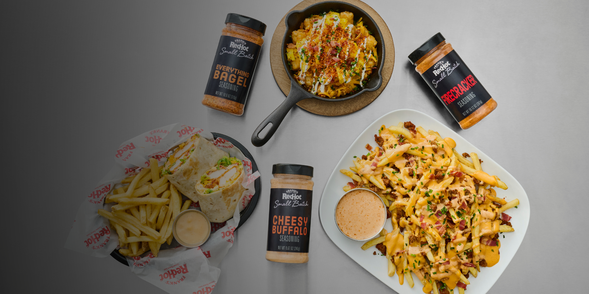 Plated food with side dishes and seasoning packets on a gray background